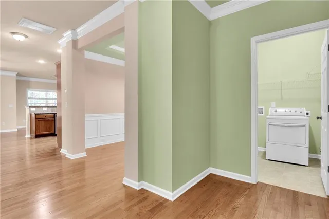 a view of a hallway with wooden floor and a kitchen