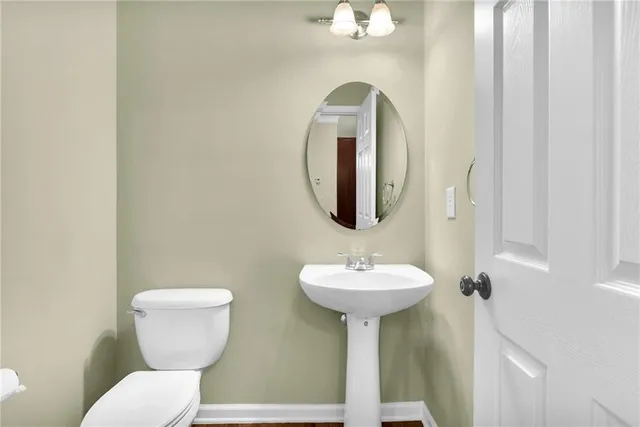 a bathroom with a toilet sink and mirror