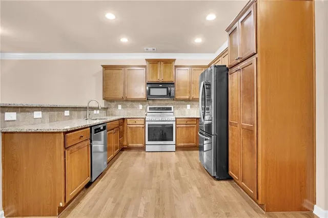 a kitchen with stainless steel appliances a refrigerator and a stove top oven