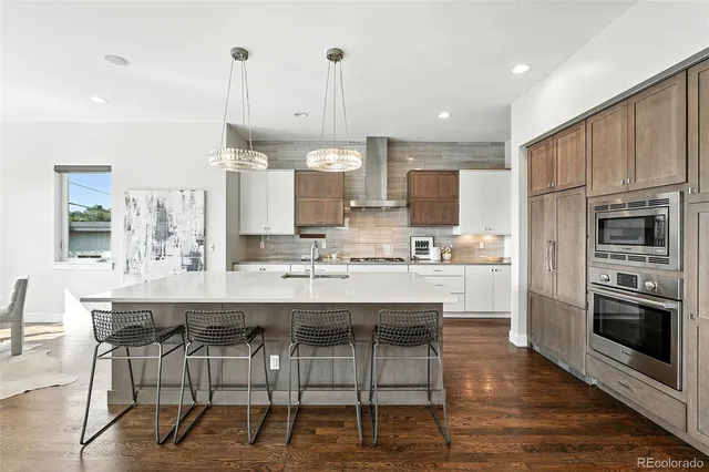 a kitchen with kitchen island granite countertop a table chairs microwave and cabinets