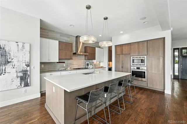 a kitchen with a center island wooden floor stainless steel appliances and cabinets