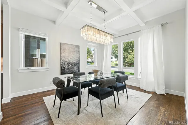a view of a dining room with furniture a chandelier and wooden floor
