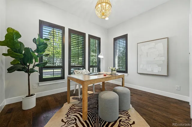 a dining room with furniture potted plants and wooden floor