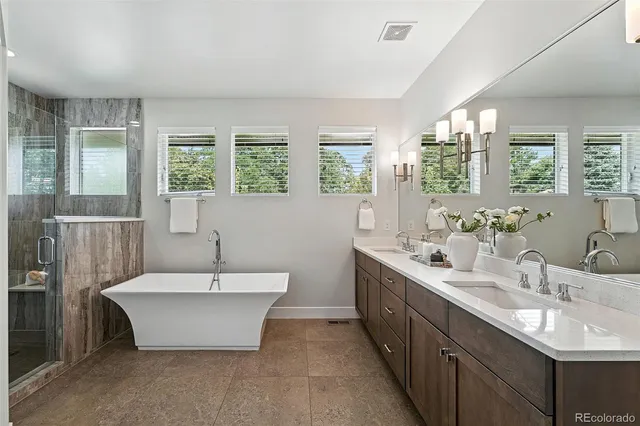 a bathroom with a double vanity sink large mirror and a bathtub