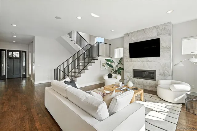 a living room with furniture a flat screen tv and a fireplace