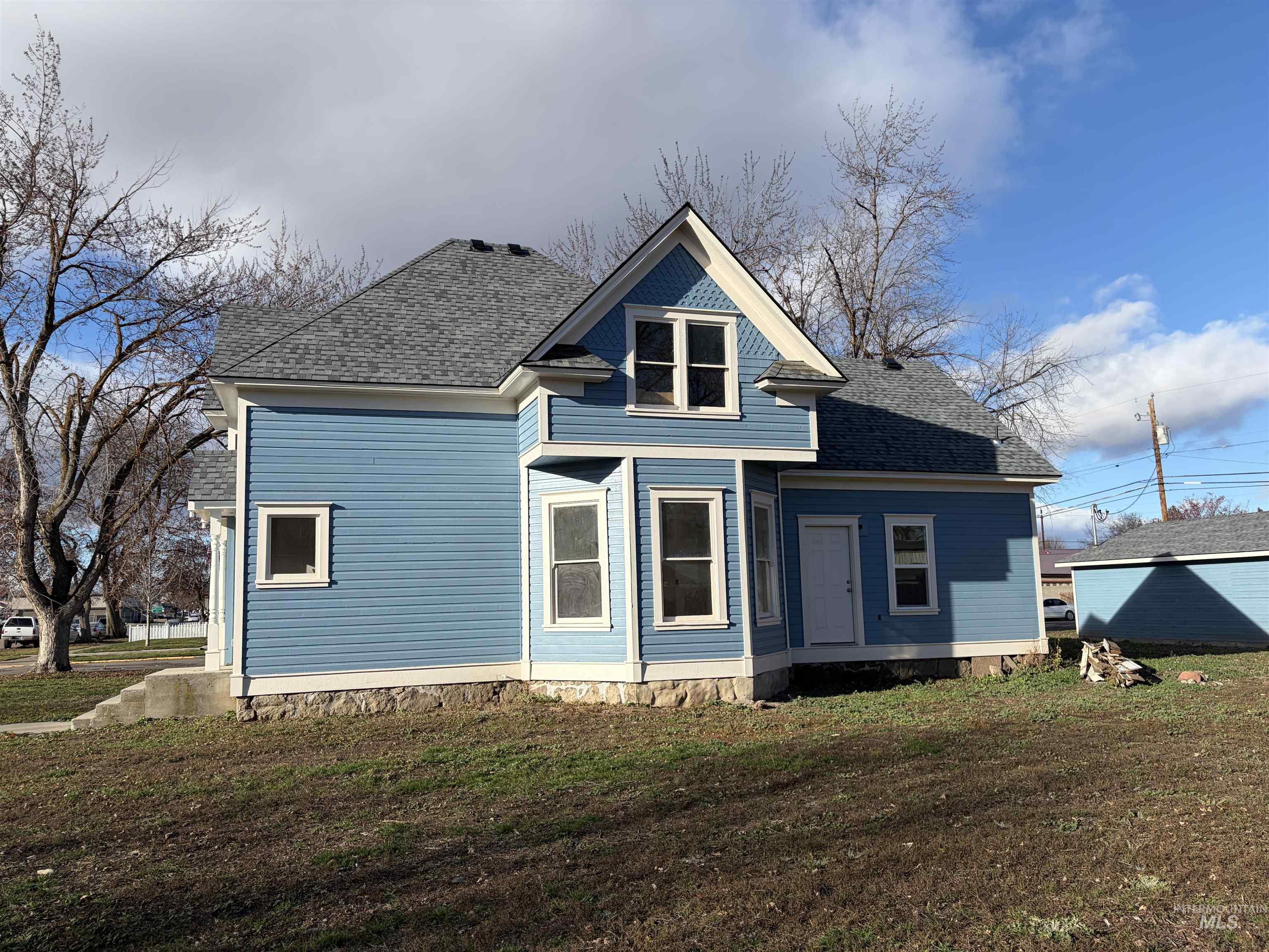 308 East Park Street Weiser, ID 83672 - Photo 6 of 50 Rear view of property featuring a shingled roof and a yard
