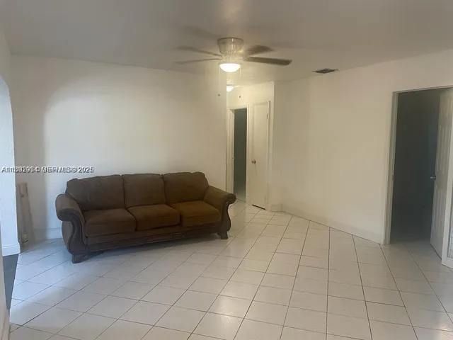 a living room with furniture and a ceiling fan
