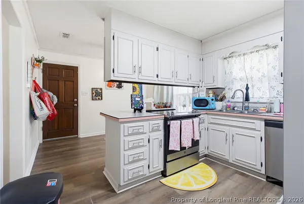 a view of a patio with table and chairs potted plants with wooden floor and fence