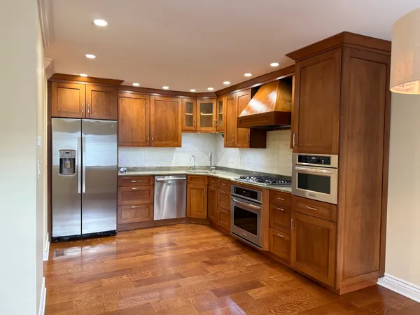 a kitchen with stainless steel appliances granite countertop a refrigerator a sink and a stove