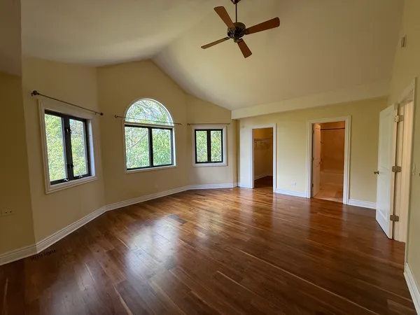 a view of empty room with wooden floor and window