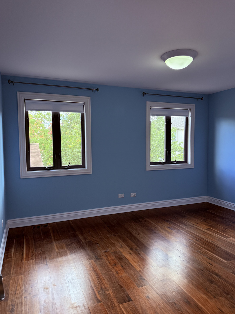 60 South Dee Road, Unit G Park Ridge, IL 60068 - Photo 17 of 23 a view of an empty room with wooden floor and a window