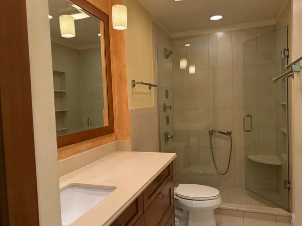 a bathroom with a granite countertop sink toilet and shower