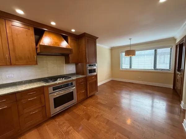a kitchen with stainless steel appliances granite countertop a stove a sink and a microwave