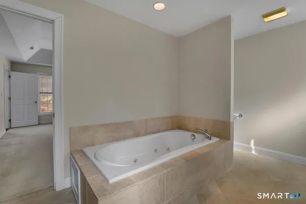a bathroom with a double vanity sink mirror and bathtub