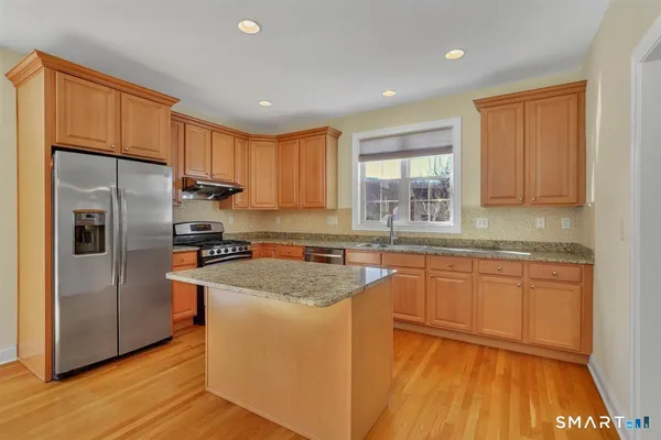 a kitchen with stainless steel appliances granite countertop a refrigerator sink and cabinets