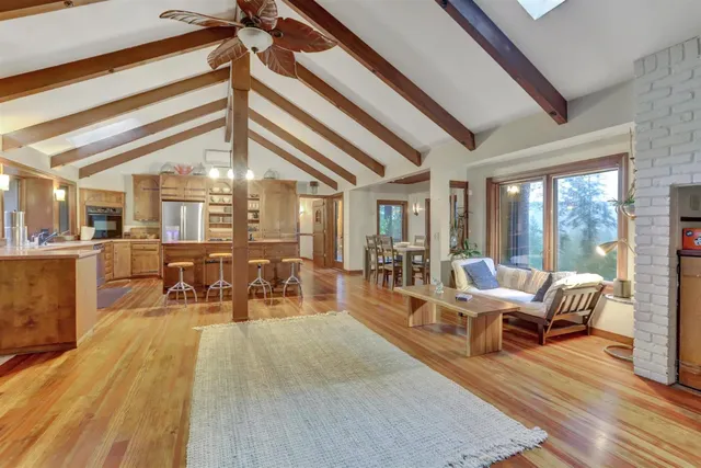 a open kitchen with granite countertop a sink and white cabinets next to a large window