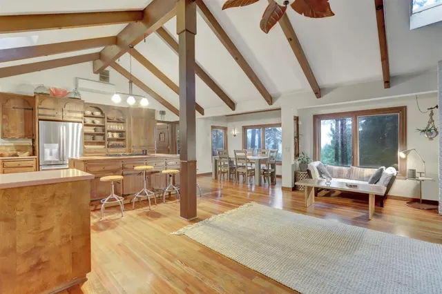 a kitchen with stainless steel appliances granite countertop a stove a sink dishwasher and a refrigerator with wooden floor