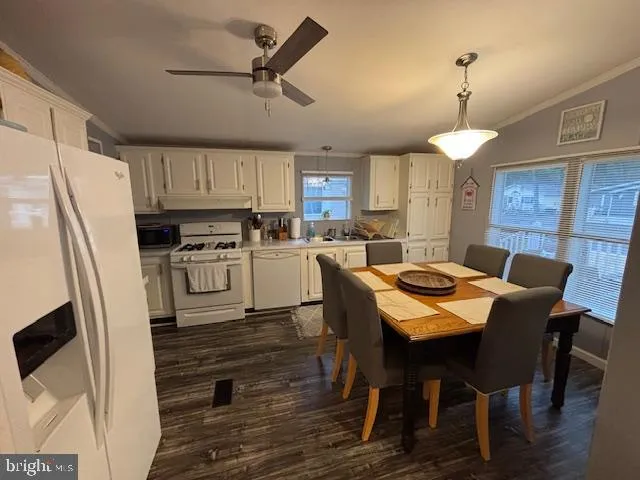 a kitchen with a table chairs refrigerator and microwave