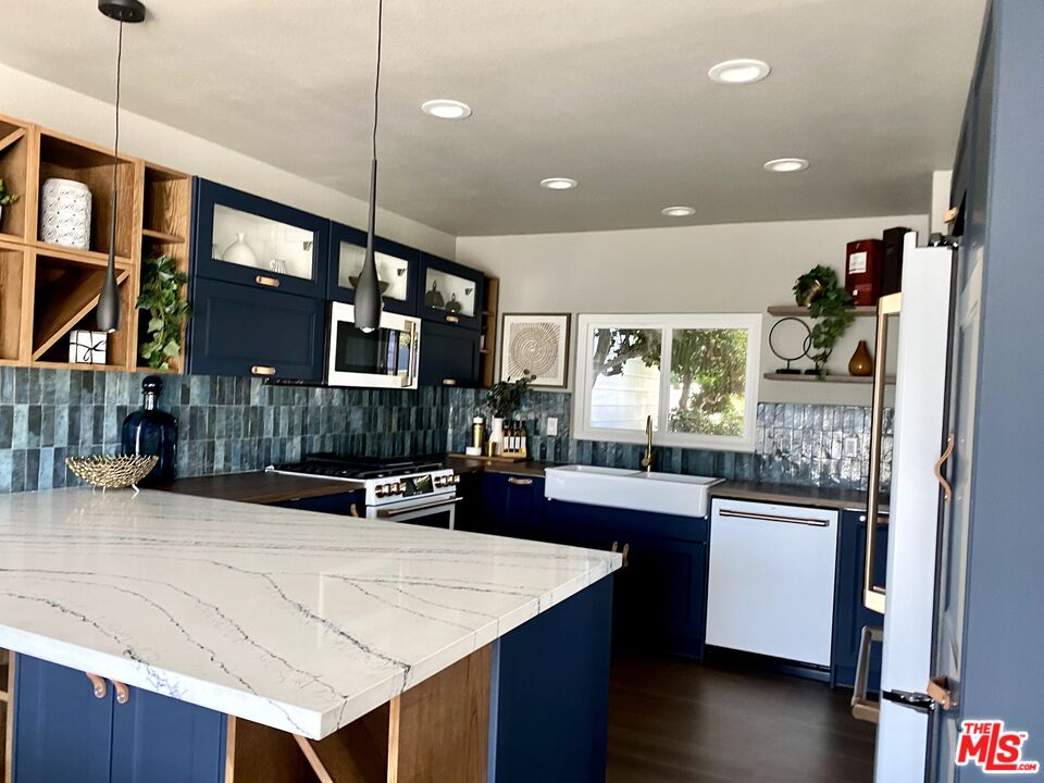 4510 Gateshead Bay Oxnard, CA 93035 - Photo 10 of 36 a kitchen with stainless steel appliances granite countertop a sink counter space and wooden floor