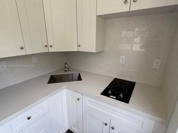 a kitchen with white cabinets and white appliances