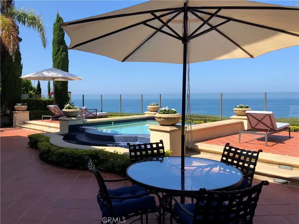 a view of a table and chairs couches under an umbrella