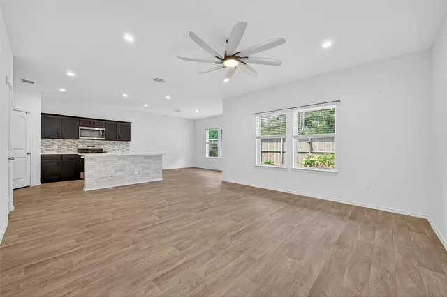 a view of a livingroom with a ceiling fan and wooden floor