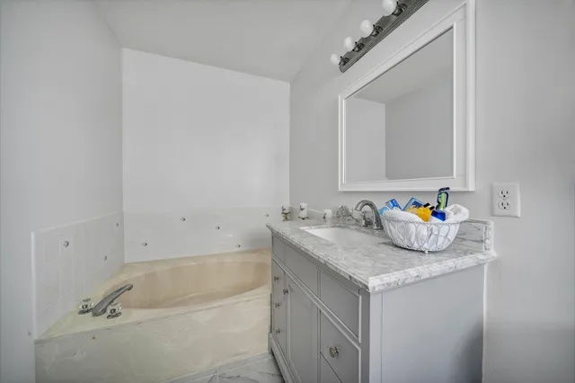 a bathroom with a granite countertop sink and a mirror