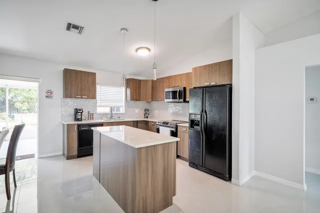 a kitchen with kitchen island a sink stove and refrigerator