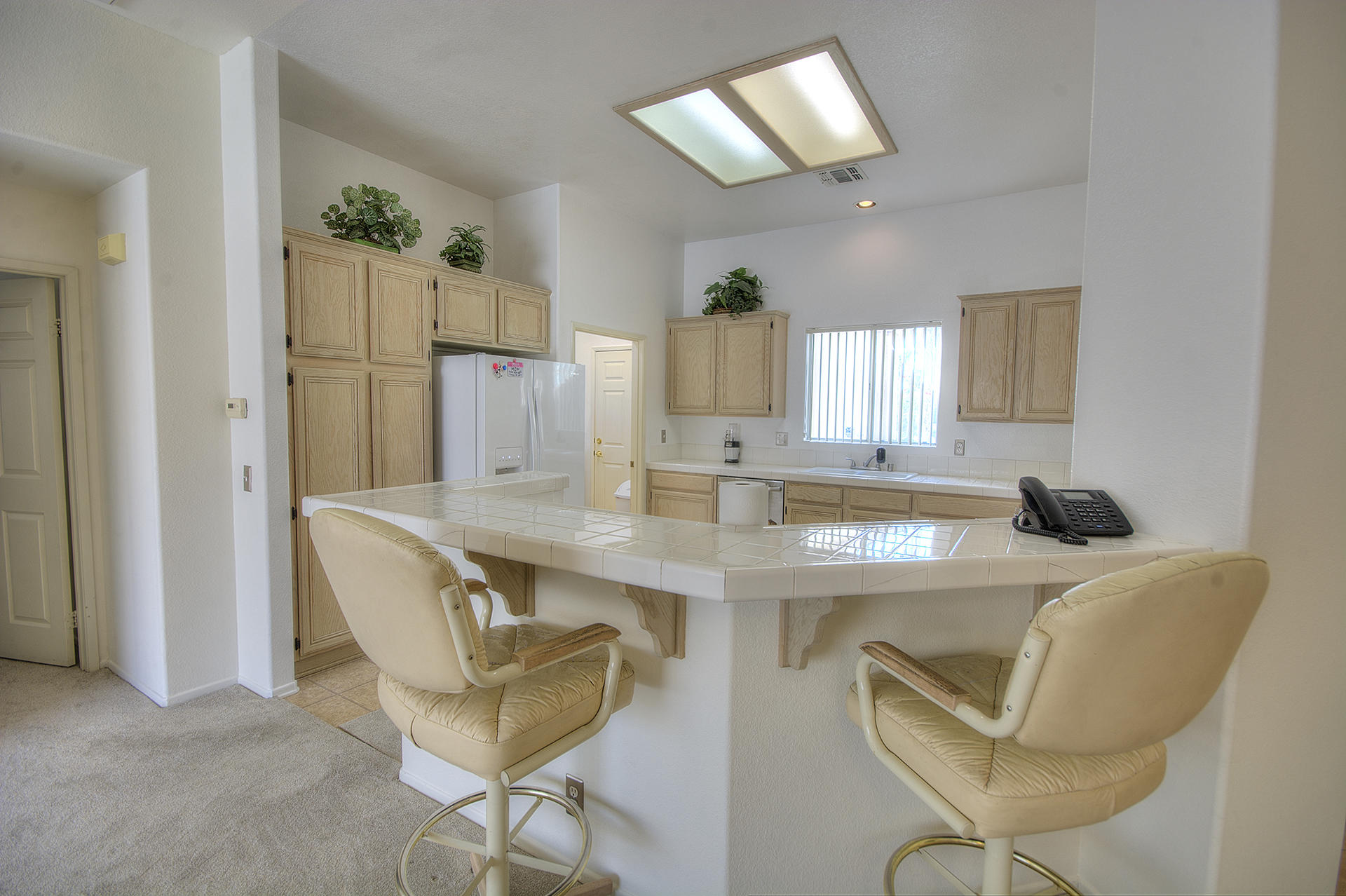 68392 Riviera Road Cathedral City, CA 92234 - Photo 8 of 21 a room with a table chairs and a refrigerator