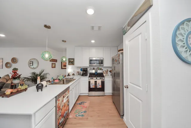 a kitchen with stainless steel appliances a refrigerator a sink dishwasher with a dining table and chairs