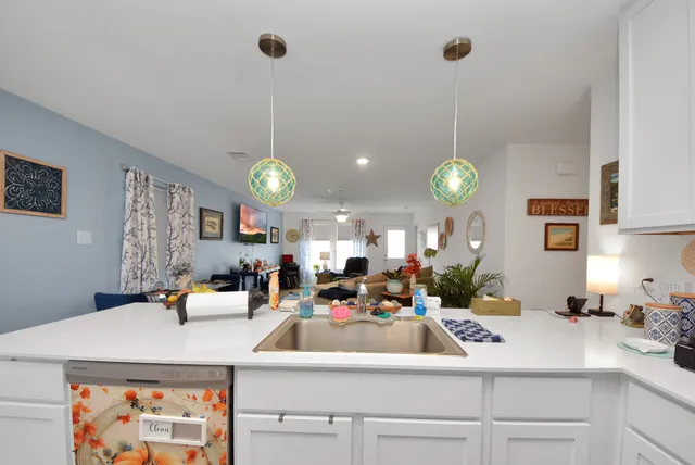 a room with kitchen island a clock and a view of living room