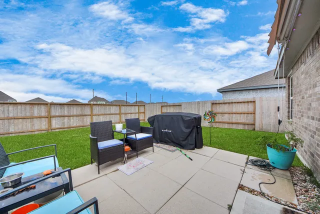 a view of a chairs and table in the back yard of the house