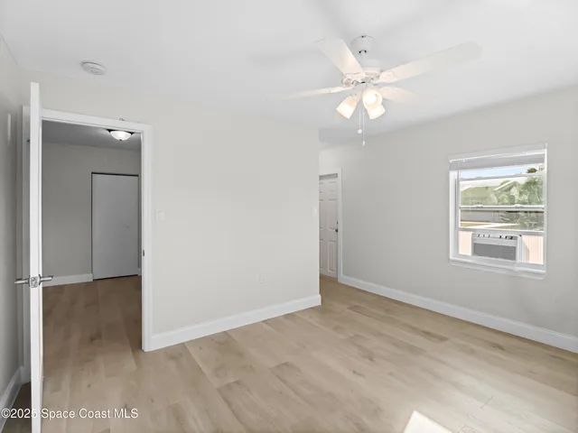 an empty room with fan and windows