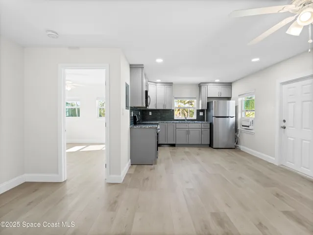 a large kitchen with a refrigerator and a stove top oven