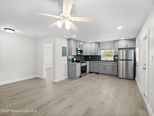 a large kitchen with cabinets and stainless steel appliances