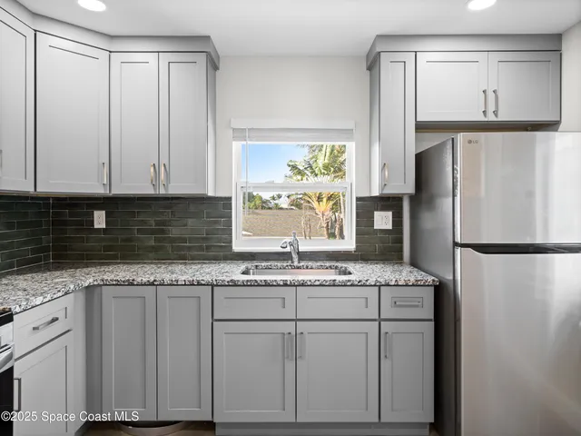 a kitchen with granite countertop cabinets and a refrigerator
