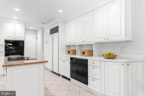 a kitchen with white cabinets and appliances