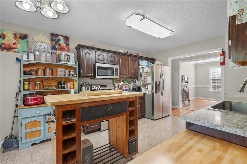 240 Orchard Way Southeast Calhoun, GA 30701 - Photo 11 of 38 a living room with stainless steel appliances furniture a rug and a kitchen view