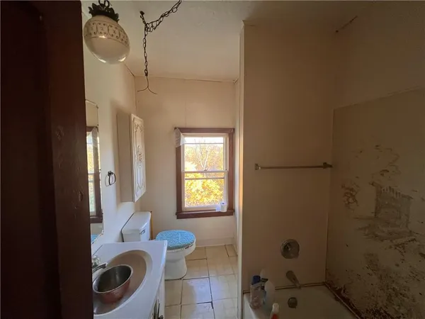 a bathroom with a granite countertop sink a toilet and shower