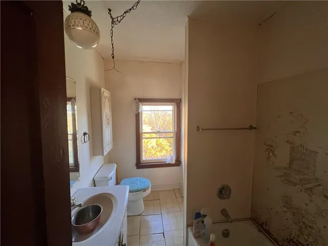 a bathroom with a granite countertop sink a toilet and shower