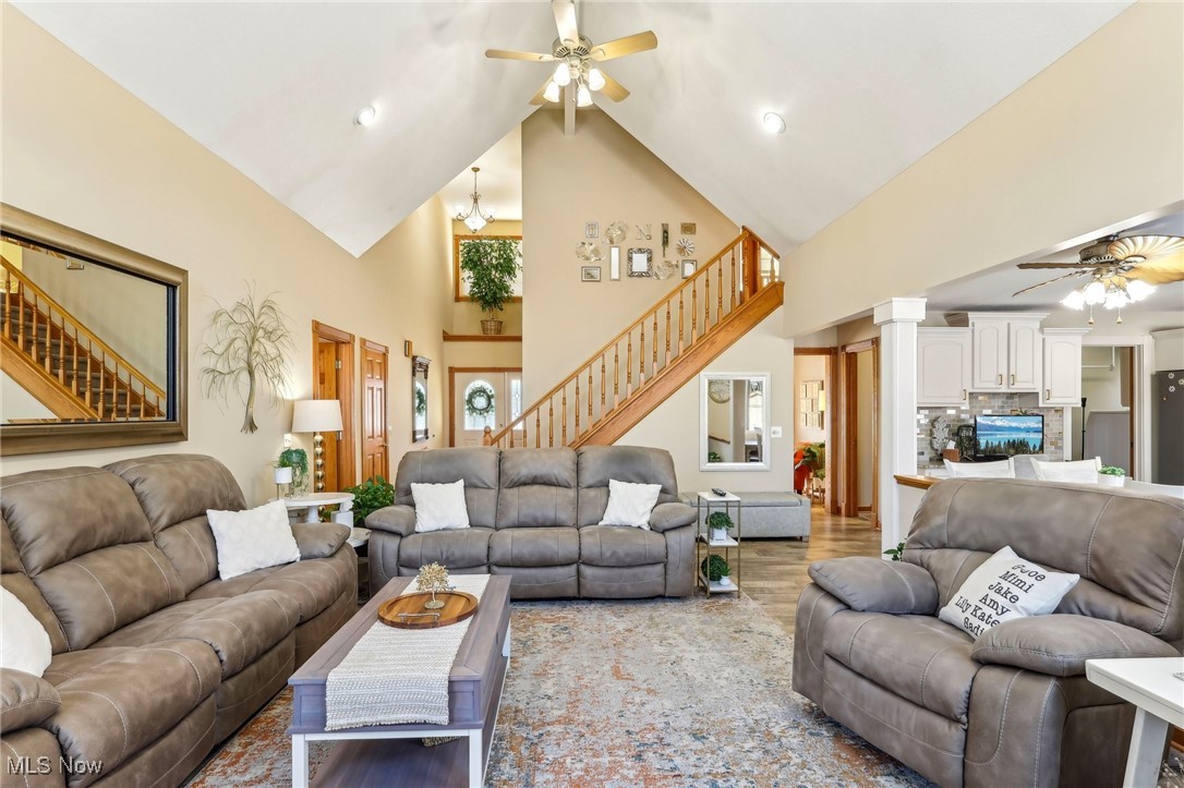 3353 Jens Way Perry, OH 44081 - Photo 4 of 49 Living room with high vaulted ceiling, light hardwood / wood-style floors, ceiling fan with notable chandelier, and decorative columns