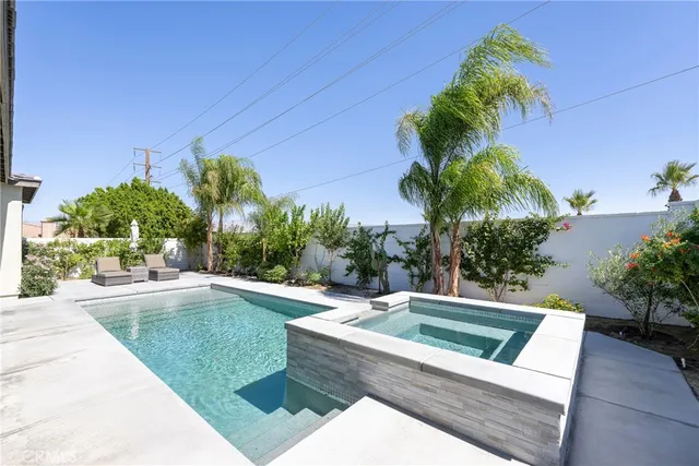a living room with furniture a flat screen tv and kitchen view