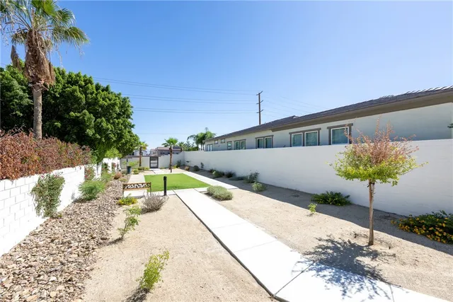 a front view of a house with a yard and potted plants