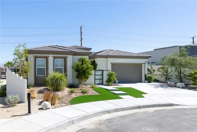 a front view of a house with a garden and plants
