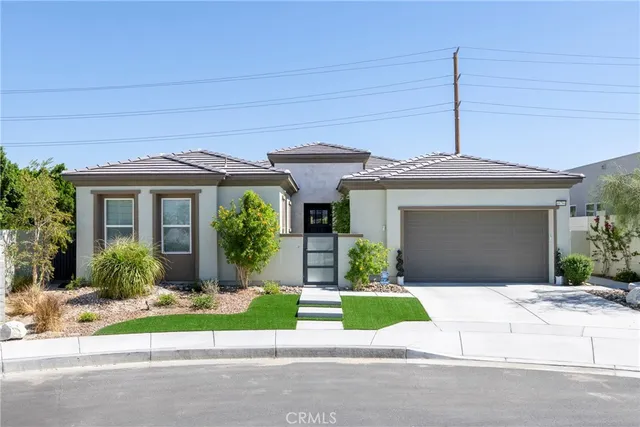 a front view of a house with a garden and plants
