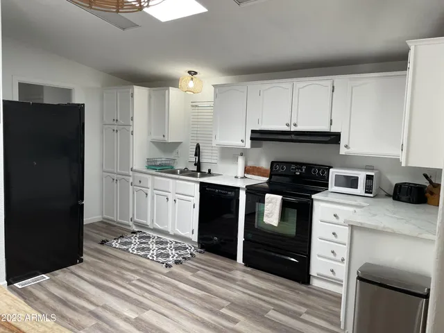 a kitchen with stainless steel appliances kitchen island granite countertop a refrigerator stove and sink