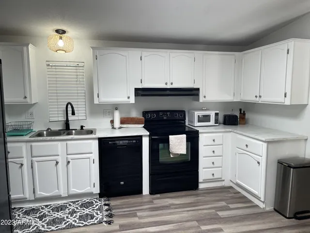 a kitchen with granite countertop white cabinets and stainless steel appliances