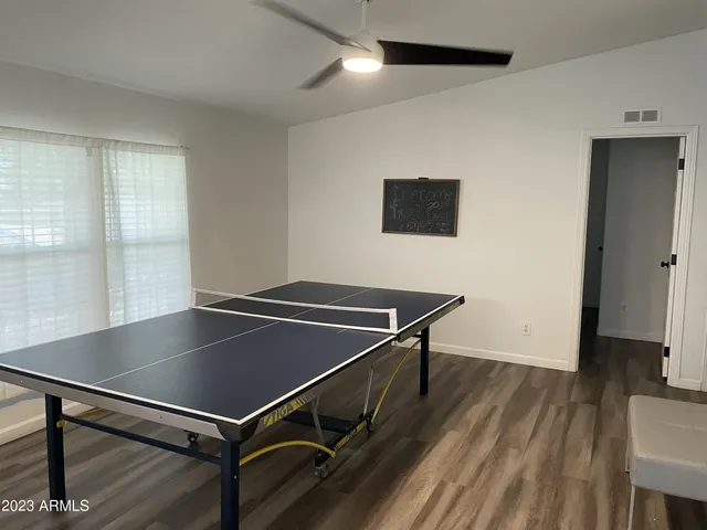 a bedroom with a bed couch and a ceiling fan