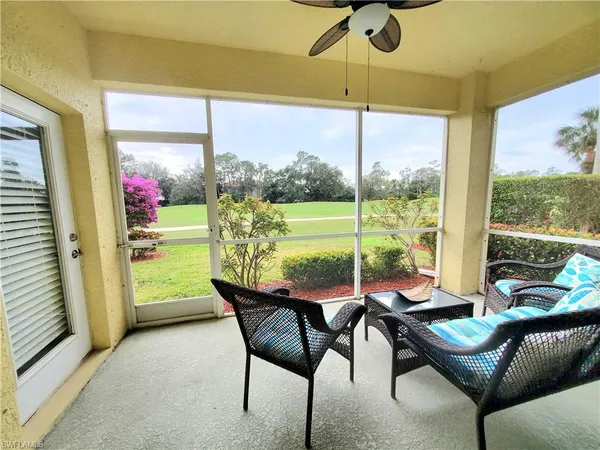 a living room with furniture and a floor to ceiling window