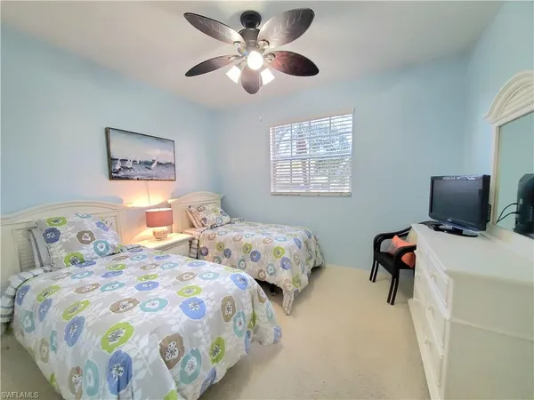 a bedroom with two beds and a chandelier